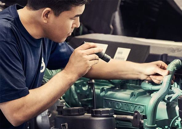 mécanicien regardant une pièce VOLVO Reman